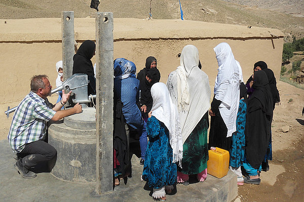 Besuch eines Wasserprojekt in der afghanischen Provinz Daykundi. Stefan Recker diskutiert mit den Dorfbewohnerinnen über die Brunnennutzung.