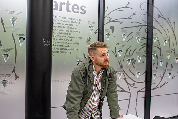 Matthias Breuer, ZFD-Fachkraft im Centro de Escucha in Apartado, schaut sich im Zentrum für Erinnerung, Frieden und Versöhnung in Bogóta die Wand der inhaftierten und verschwundenen Personen an.