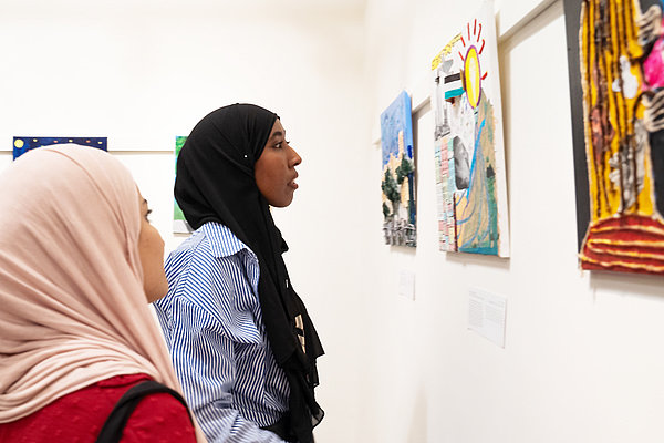 Gäste besuchen die JRS-Kunstausstellung in Jadal. sie wurde anlässlich des Internationalen Tages des Friedens organisiert.