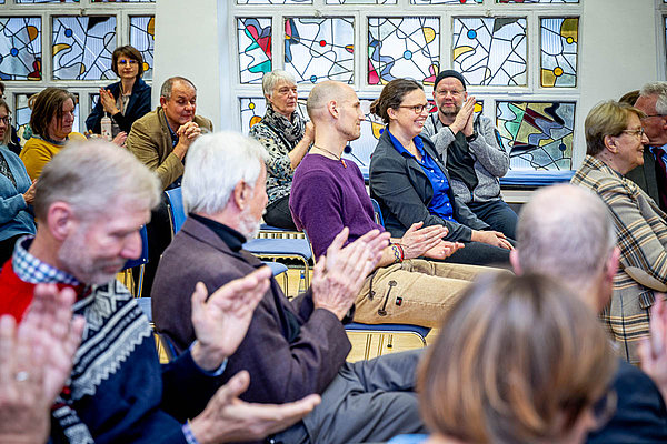 viele Menschen sitzen in einem Saal