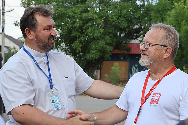 Besuch in der Oblast Mykolayiv, wo ein gemeinsames Wiederaufbauprojekt mit Caritas Ukraine geplant ist. Vater Taras Pavlius (li.), Direktor der Caritas Ukraine in der Oblast Mykolayiv, begrüßt Stefan Recker.