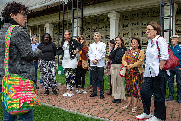 Die Teilnehmer*innen des Treffens sind zu Besuch im "Zentrum für Erinnerung, Frieden und Versöhnung" in Bogotá. Die Gruppe hört einer Expertin zu, die die Geschichte des gewaltsamen Verschwindenlassens in Kolumbien erzählt.