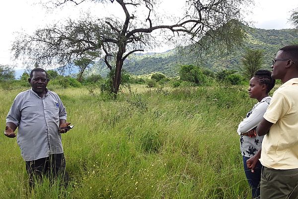 Father Victor Mwekwasize zeigt dem Cross-Border Peace-Team die gute Bodenfruchtbarkeit ‎des Landes und die heimischen Pflanzen. ‎