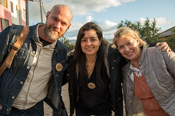 Eine Gruppe von Fachkräften wartet vor der Sozialpastoral auf den Bus:
Matts Olsson, Sara Buitrago, Monika Lauer-Perez (von links)